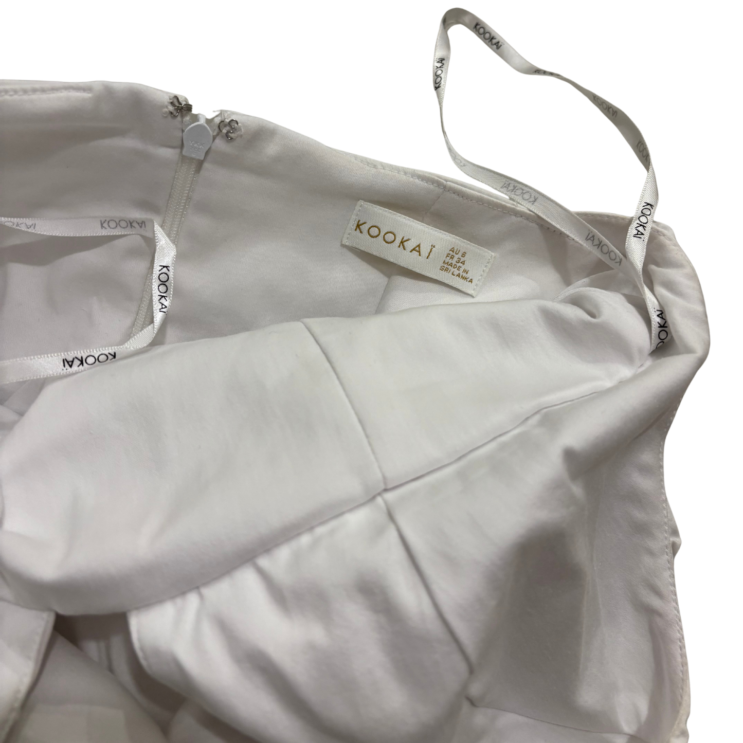 White strapless top with 'Kookai' label on a white background